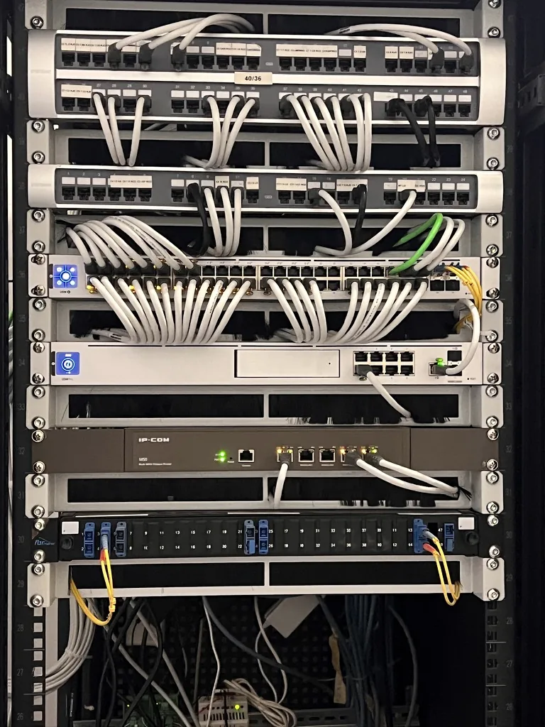 Baie réseau UniFi avec deux panneaux de brassage 48 ports et cordons blancs rangés
