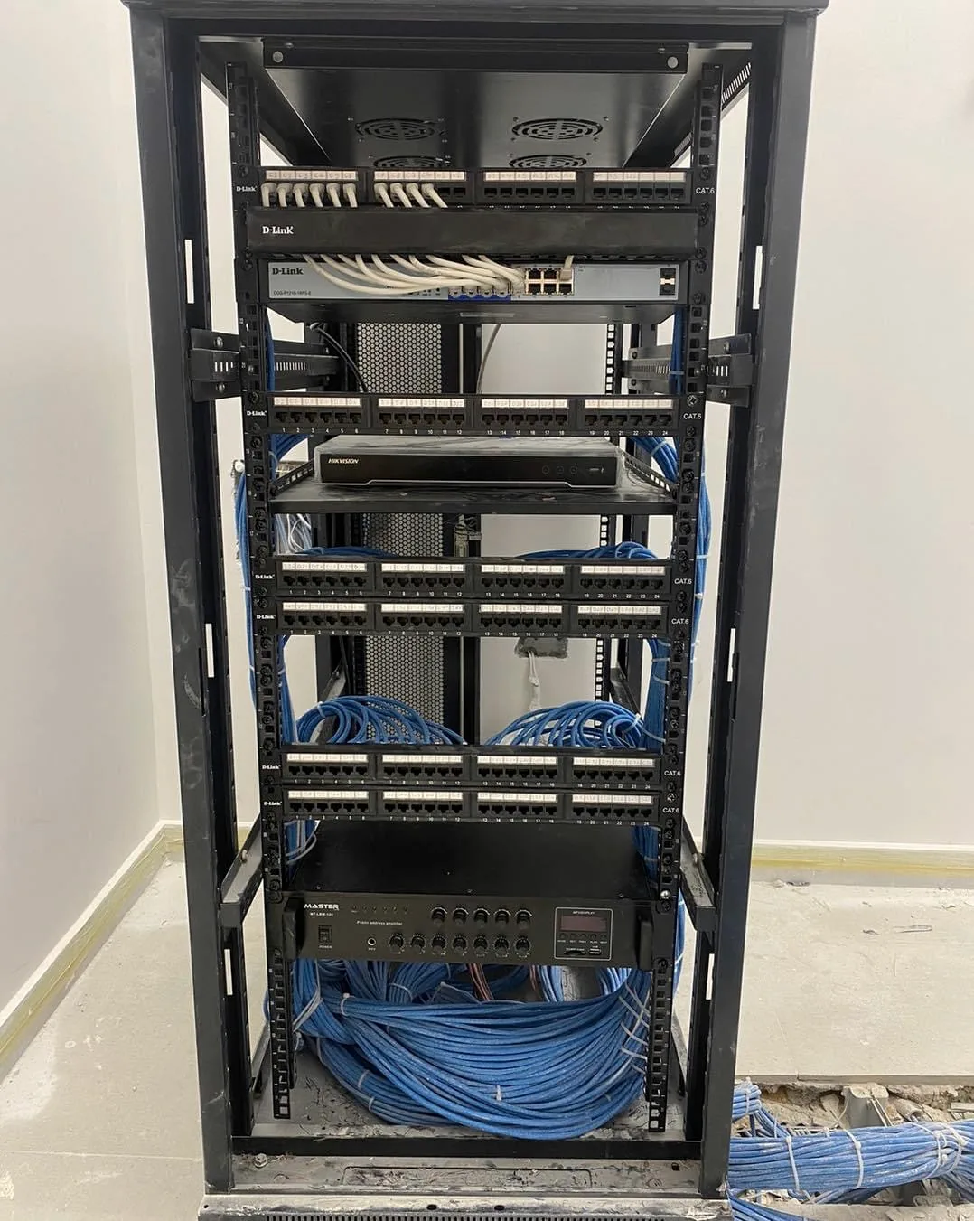 Baie avec panneaux de brassage, enregistreur Hikvision et amplificateur de sonorisation